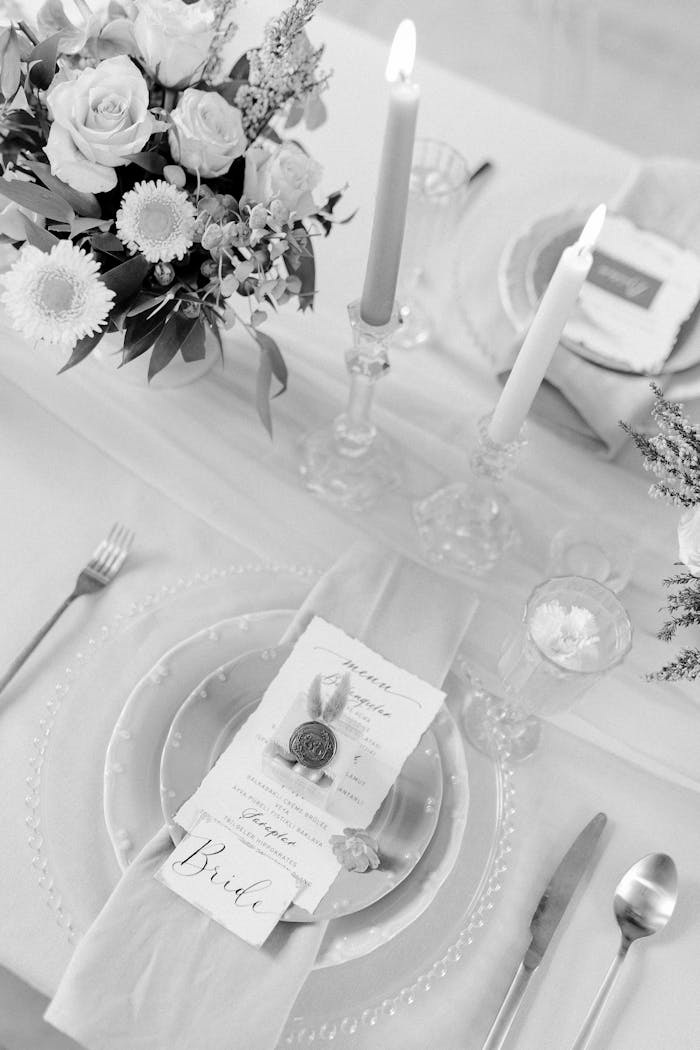 Elegant black and white wedding table setup with flowers and candles.